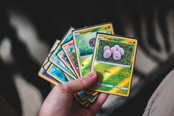 Collection of Pokémon trading cards arranged by rarity, including common, rare, and ultra rare cards.